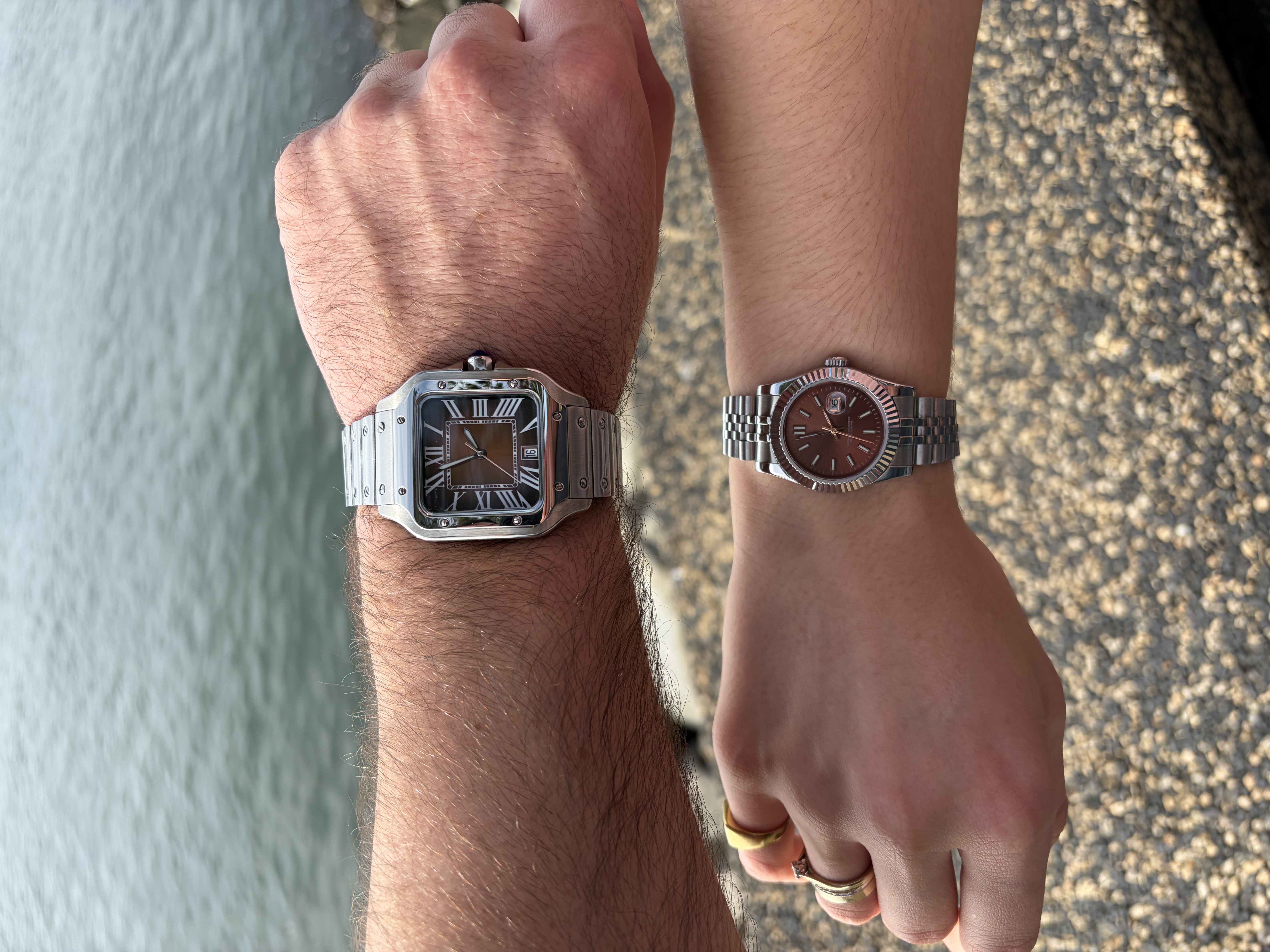 His and hers wristshot at Newcastle harbour — a Cartier Santos homage on his wrist, a chocolate Datejust homage NH05 on hers